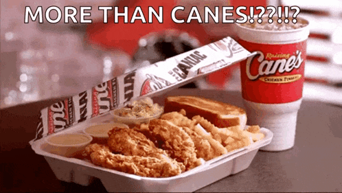 a styrofoam container filled with fried chicken and french fries next to a cane 's drink