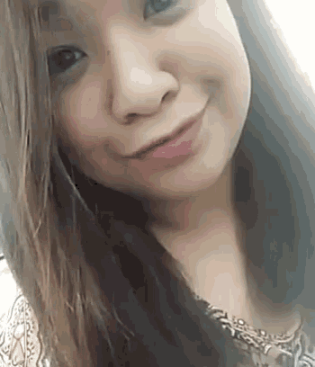 a close up of a woman 's face with long hair and a smile .