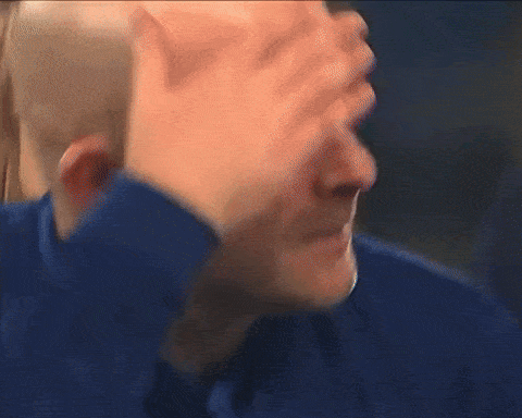 a bald man with his hand on his head