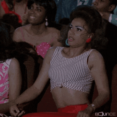 a woman in a striped crop top is sitting in a theatre .