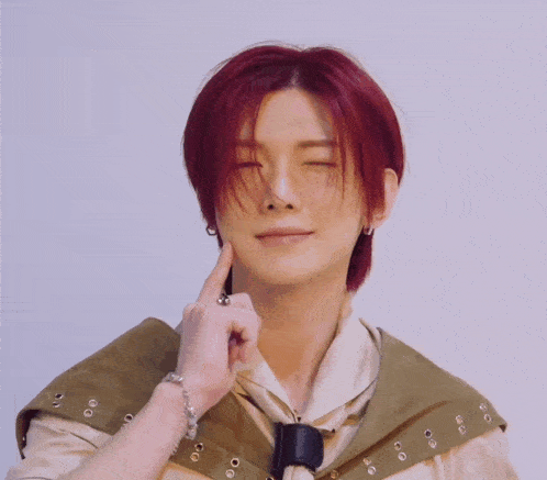 a young man with red hair is making a funny face