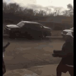 a black car is parked on the side of the road in front of a house .