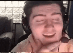 a man wearing headphones and a microphone is making a face .