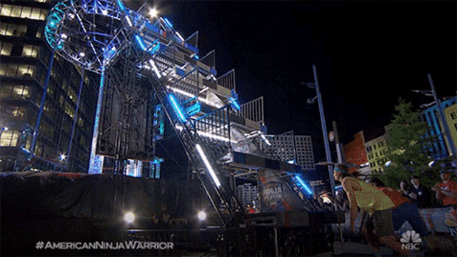 a nbc advertisement for american ninja warrior shows a man jumping off a ladder