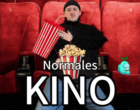 a man is holding a bucket of popcorn in a movie theater with the words normales kino below him