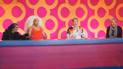 a group of people are sitting at a table with circles in the background .