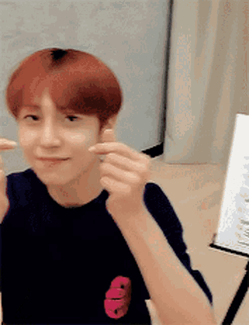a young man with red hair is giving a thumbs up sign