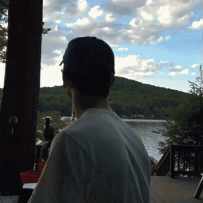 a man looking out over a lake with a mountain in the background
