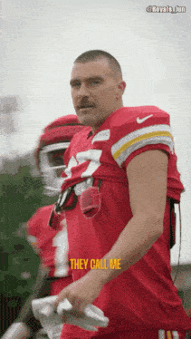 a man with a mustache wearing a red jersey that says they call me on it