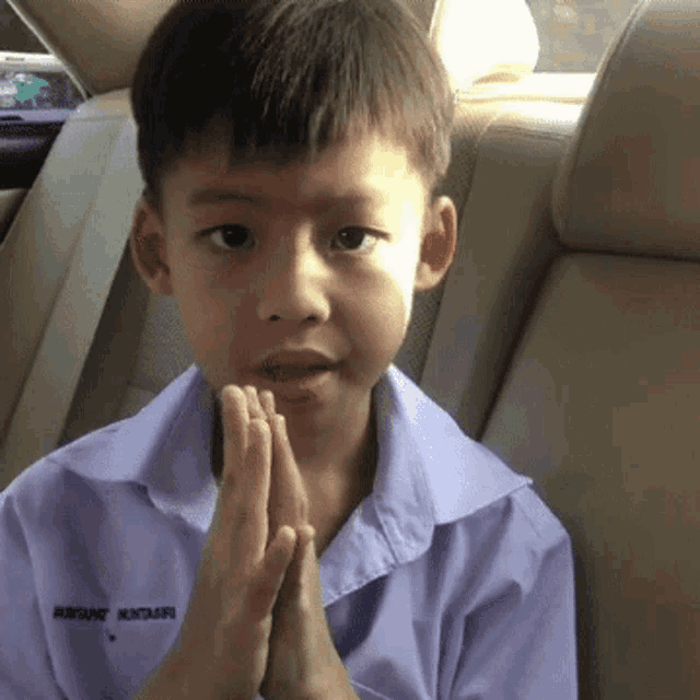 a young boy wearing a shirt that says ' hong kong ' on the collar