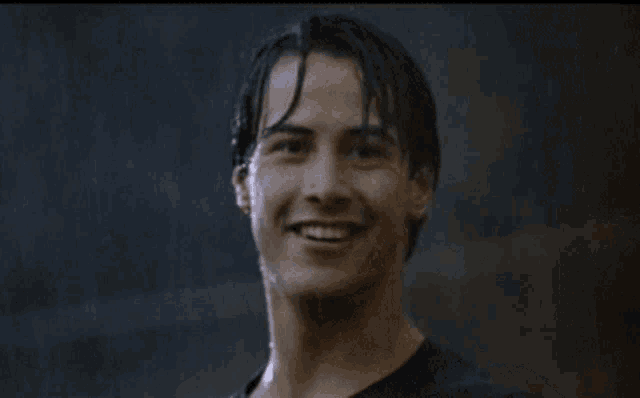 a man with wet hair is giving a thumbs up in the rain