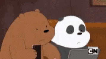two bears are standing next to each other and one is using a laptop .