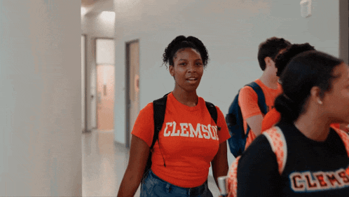 a girl wearing an orange shirt that says clemso