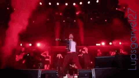 a man in a blue jacket is singing into a microphone