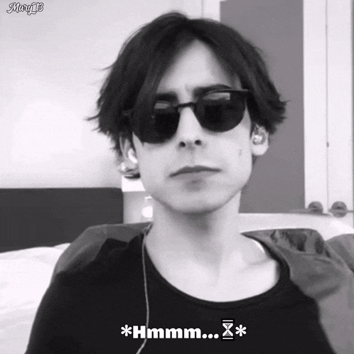 a black and white photo of a man wearing sunglasses and ear buds