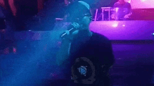 a man is singing into a microphone while wearing headphones