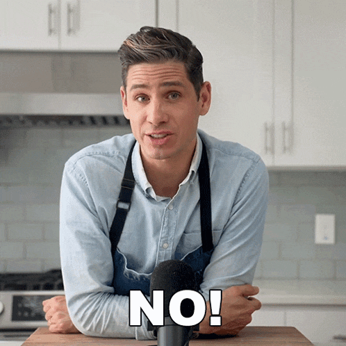 a man in an apron stands in front of a microphone with the word no written on it
