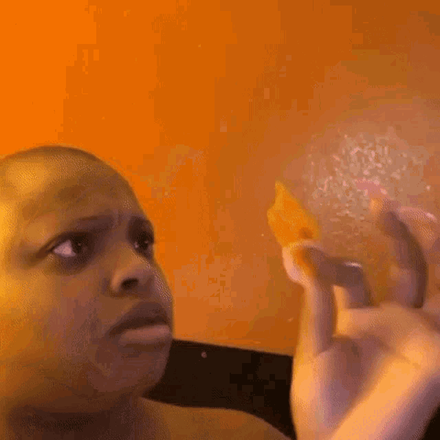 a blurry picture of a man holding a piece of food in his hands .