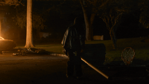 a person is laying on the ground in front of a car that is burning