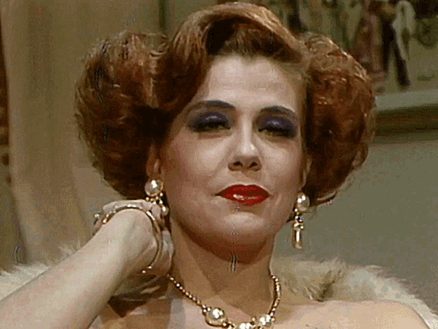 a woman wearing a pearl necklace and earrings