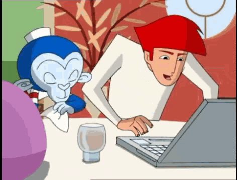 a man and a monkey are looking at a laptop computer