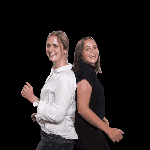two women are standing back to back and one is wearing a watch