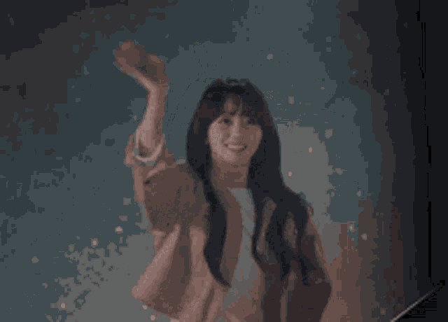 a woman in a pink jacket is waving her arm in the air