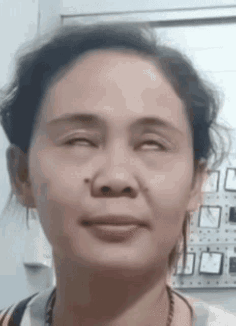 a close up of a woman 's face with her eyes closed and smiling .