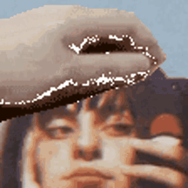 a close up of a person 's face with a hand covering it .