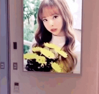 a picture of a girl holding a bouquet of yellow flowers in front of a mirror .