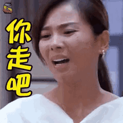 a woman in a white dress is making a funny face with chinese writing on her face .