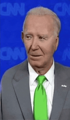 a man in a suit and tie is standing in front of a cnn background .