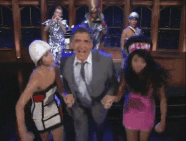 a man in a suit and tie is surrounded by three women
