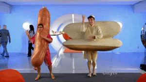 a man dressed as a hot dog and another man dressed as a hot dog