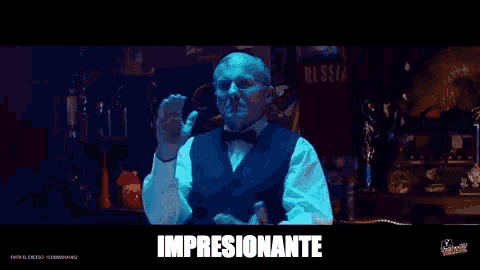 a man in a tuxedo and bow tie is making a hand gesture with the word impresionante written below him