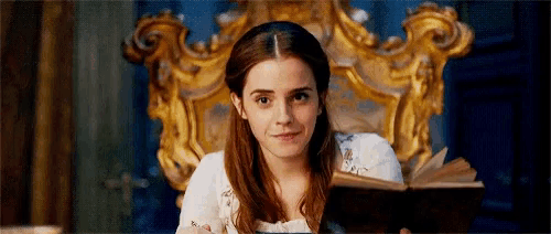 a woman is sitting on a chair reading a book .