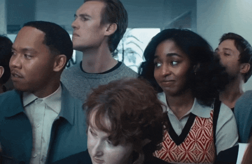 a group of people are standing in a line looking up