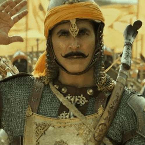 a man with a mustache is wearing a helmet and armor .