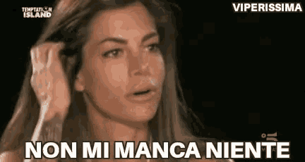 a woman is holding her hair and saying `` non mi manca niente '' in a foreign language .