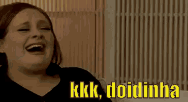 a woman is laughing while sitting on a couch with the words kkk doidinha written on the bottom