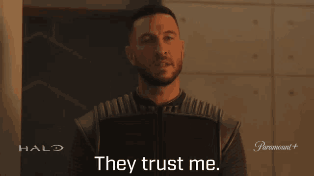 a man says they trust me in front of a halo sign