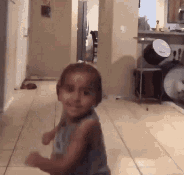 a little girl is standing in a hallway in front of a drum set