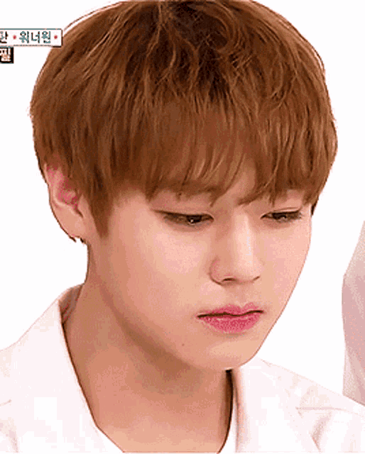 a close up of a young man 's face with korean writing on the bottom right