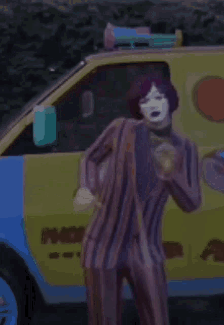 a man in a striped suit is standing in front of a mcdonald 's truck .