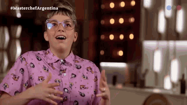 a woman wearing glasses and a pink shirt that says masterchef argentina on the bottom