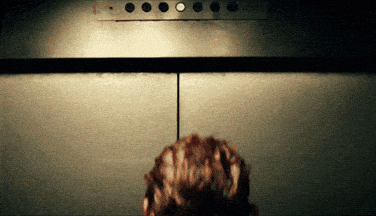 a person is standing in an elevator looking at the buttons