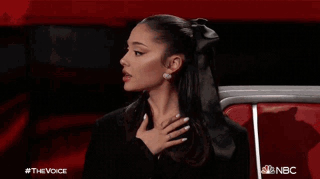 a woman with a bow in her hair is sitting in a chair with her eyes closed