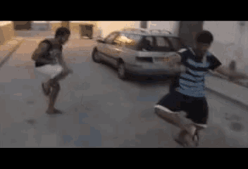 a man in a blue and white striped shirt is running down a street