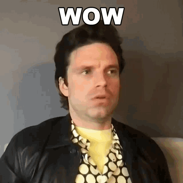 a man wearing a polka dot shirt and a leather jacket is making a surprised face with the word wow written above him .