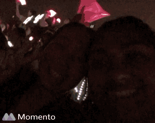 a woman is holding a pink light in her hand and the word momento is on the bottom left